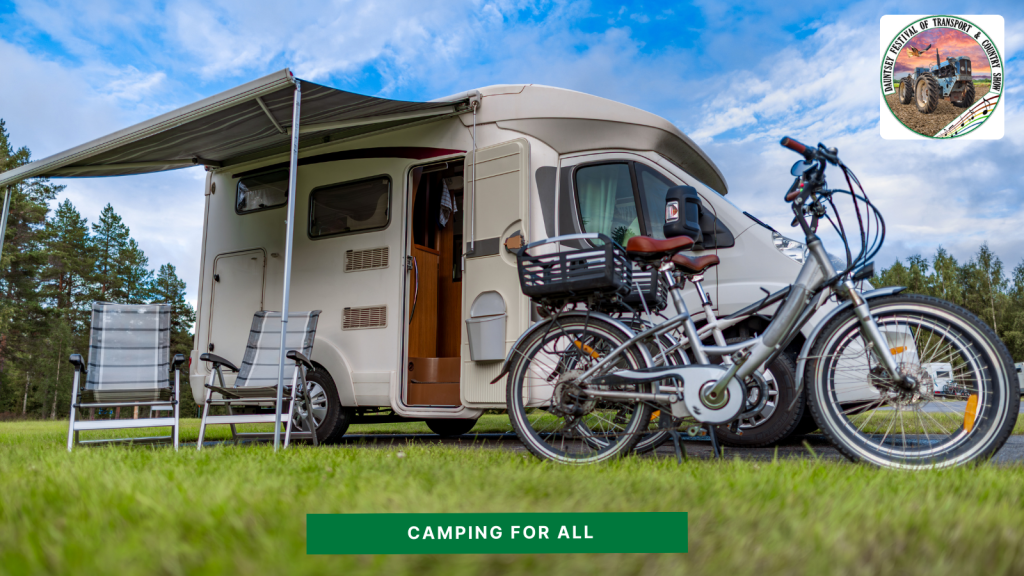 Camping - motorhome in a field with electric bikes and chairs beside it.